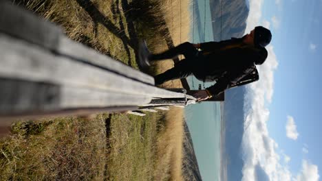 excursionista masculino subiendo la valla de ganado en las tierras altas de nueva zelanda