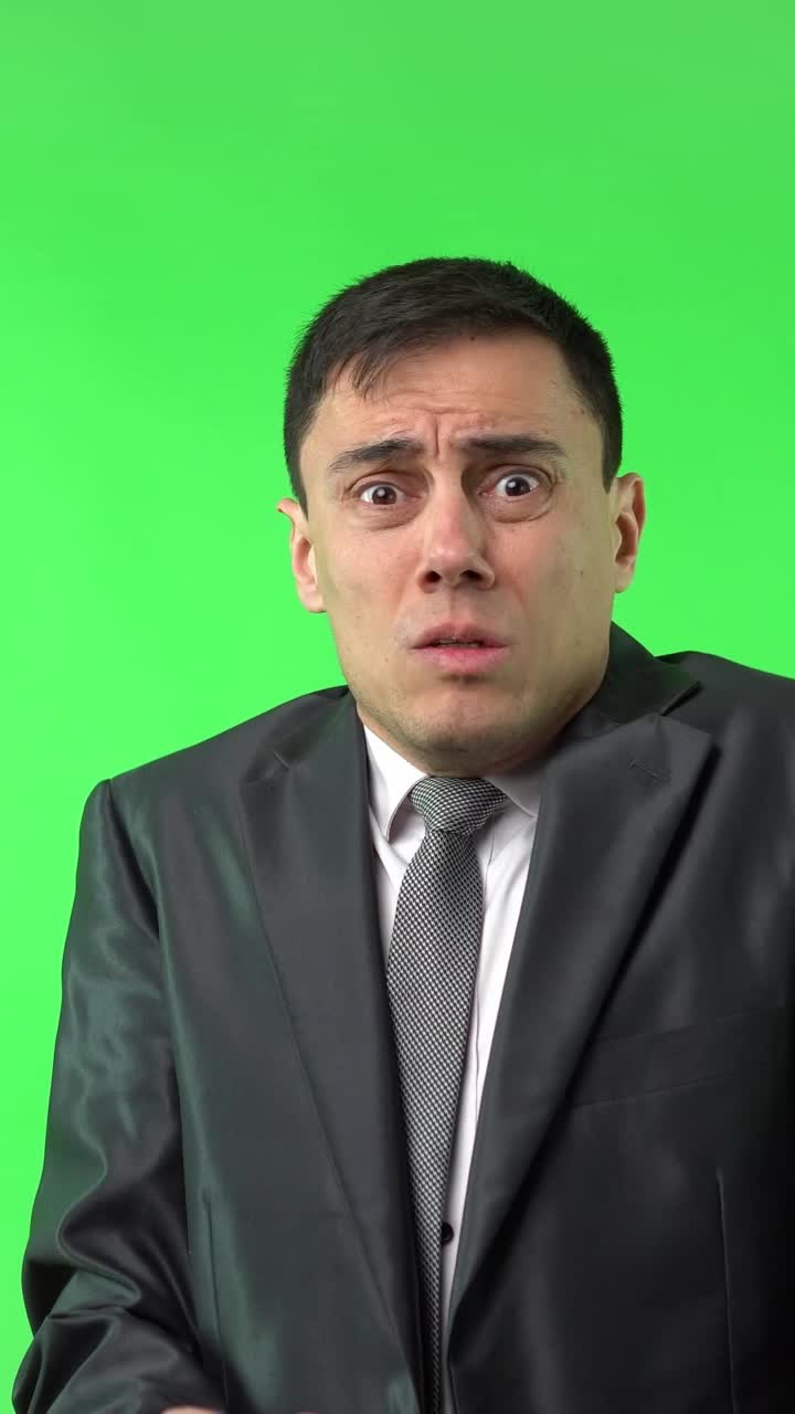 Man in suit reacts with shock on green screen