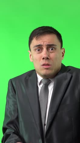 man in suit reacts with shock on green screen
