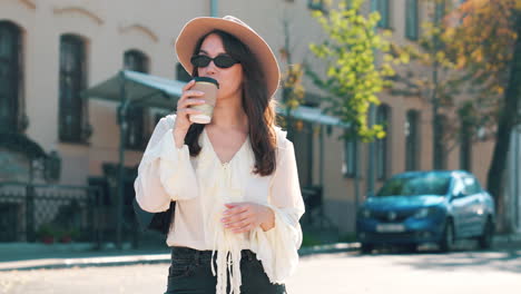 woman drinking coffee on city street