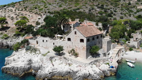 Toma-Aérea-De-Drones-De-Una-Antigua-Villa-De-Piedra-En-Una-Playa-En-La-Isla-De-Hvar,-Croacia