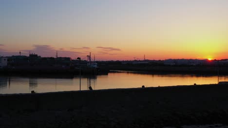 stunning golden hour sun rises above skyline illuminating nimmo's pier galway ireland with epic reflection