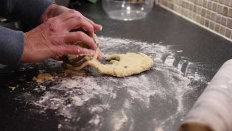 close-up shot of a baker using a rolling pin and cookie cutter on a scone mixture