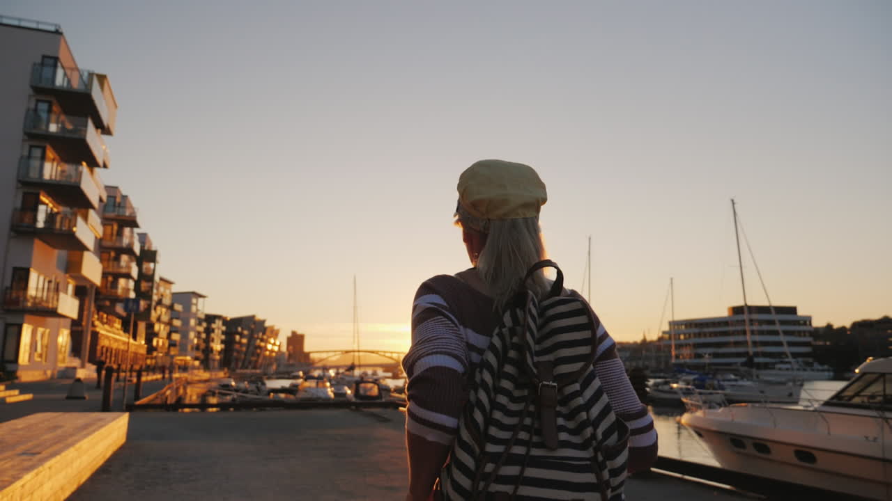 mujer activa se regocija al amanecer sobre el puerto deportivo corre hacia adelante levanta las manos al amanecer en bergen