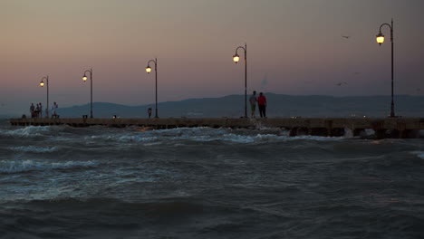 people on pier in the windy evening