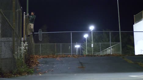 skater jumps off of a huge fence