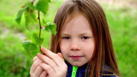 young girl examining a spring branch