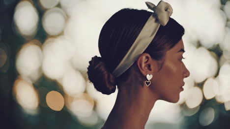 elegant woman with heart earrings and headband in profile