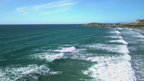 toma lateral aérea de un surfista atrapando una ola en la playa fistral, newquay, cornwall