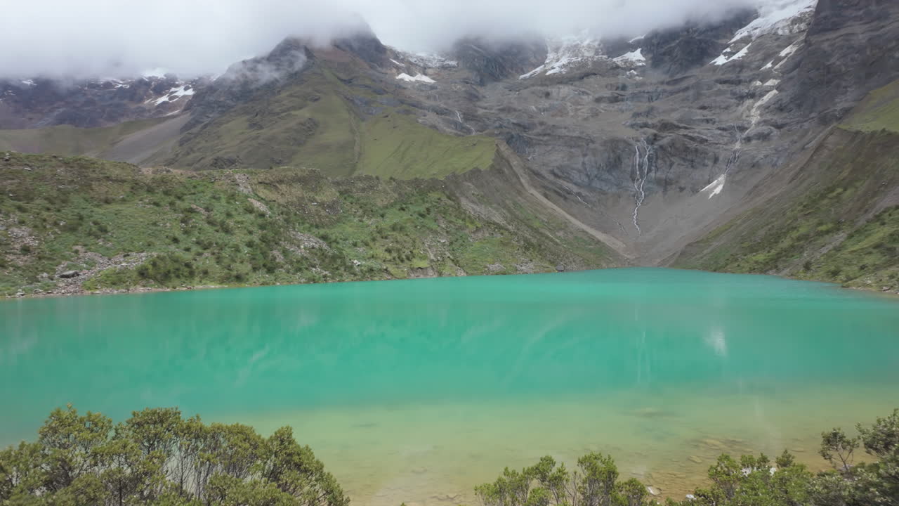 Turquoise Humantay Lake with snow-capped Humantay and Salkantay peaks in slow motion
