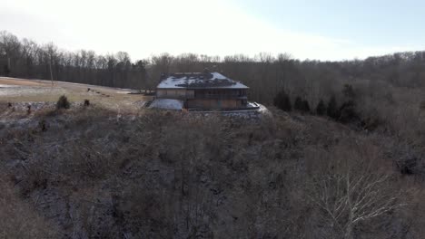 Imágenes-Aéreas-De-Drones-Que-Se-Desplazan-Hacia-Un-Albergue-Abandonado-En-Una-Colina-Durante-El-Invierno