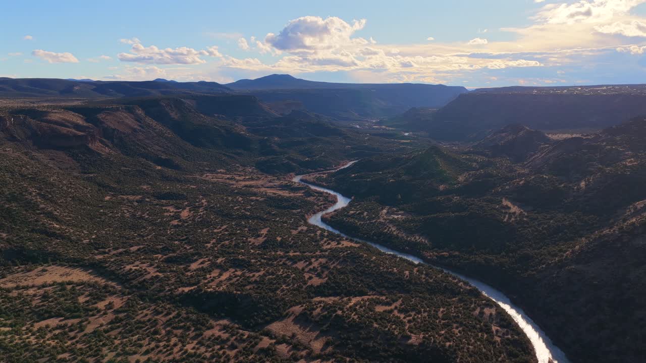 Vivi la maestosa pace di un fiume blu serpeggiante che scorre attraverso un profondo canyon desertico. Questa splendida prospettiva dall'alto offre una transizione paesaggistica versatile per documentari di viaggio
