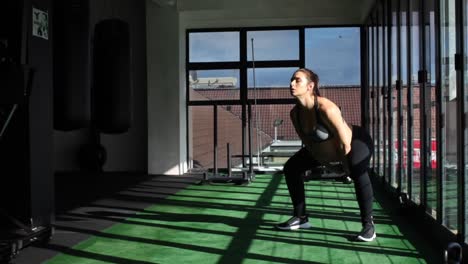 imágenes de vídeo de una modelo de fitness femenina embarazada haciendo ejercicios con pesas rusas en un gimnasio durante su tercer trimestre de embarazo.