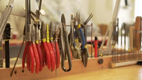 Close-up-of-workroom-full-of-pliers,-tweezers,-splitters,-files-and-other-tools