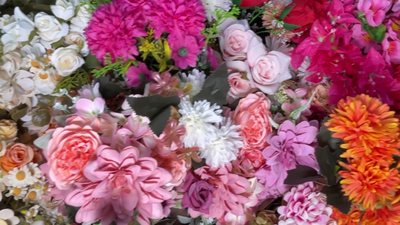 Panorâmica em Close-Up de uma Parede de Flores Artificiais Coloridas