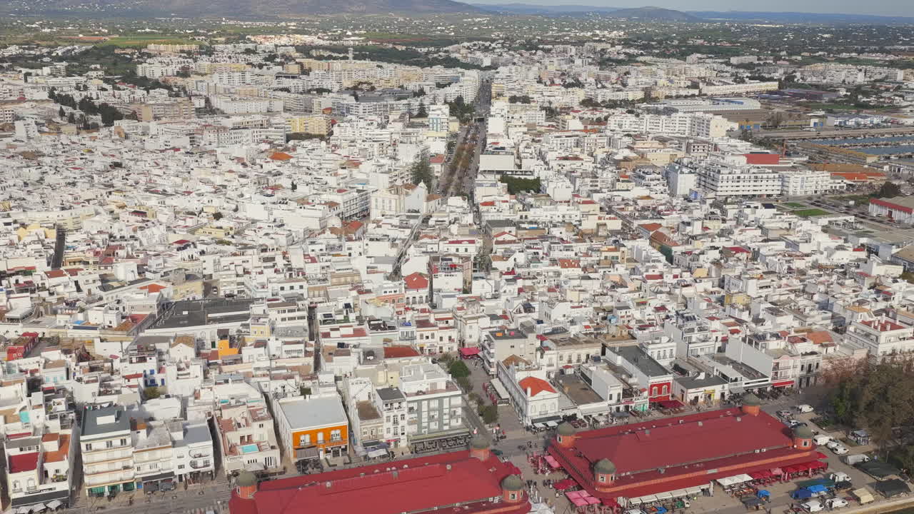 Voo de drone aéreo para trás sobre as casas brancas da cidade de Olhão, Algarve, Portugal