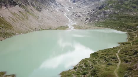 alto vuelo de drones sobre el lago y el glaciar stein en los alpes de urner en suiza