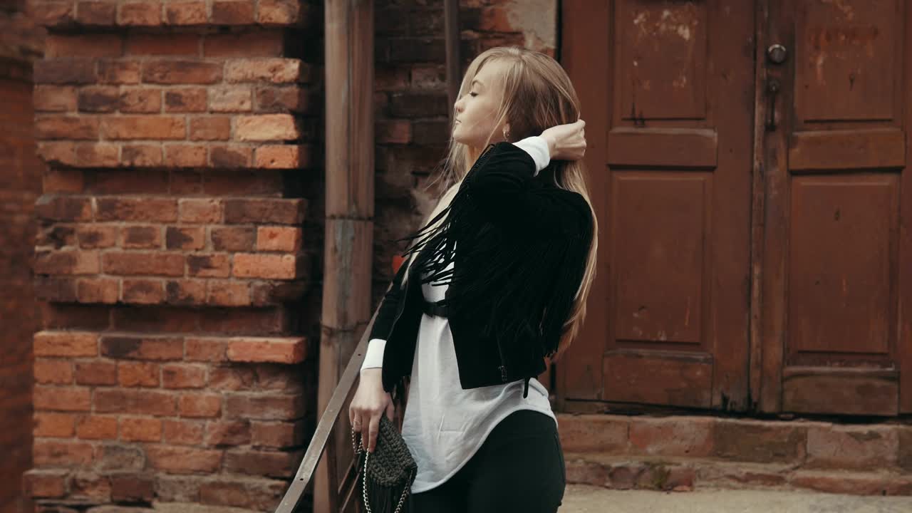 Beautiful woman in urban background with copy space. Young woman posing outdoors