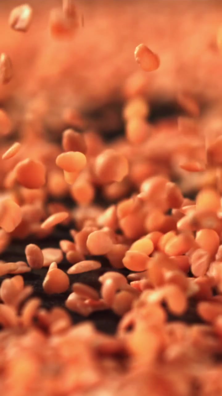 Røde linser som faller i sakte film ned på en mørk overflate