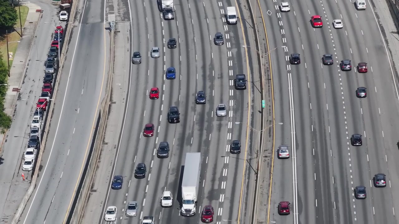 Caminhões semirreboque e carros circulando nas várias faixas do Downtown Connector em Atlanta, Geórgia. - Tomada aérea.