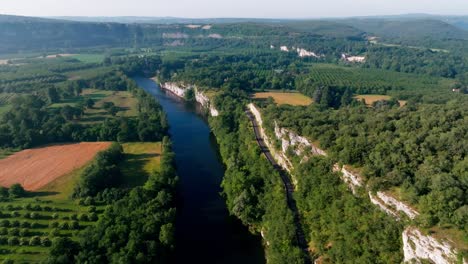 drone shot over a river with cliffs, the water is blue