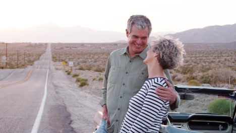 Una-Pareja-Mayor-Parada-Junto-Al-Coche-Sonriendo-A-La-Cámara,-De-Cerca