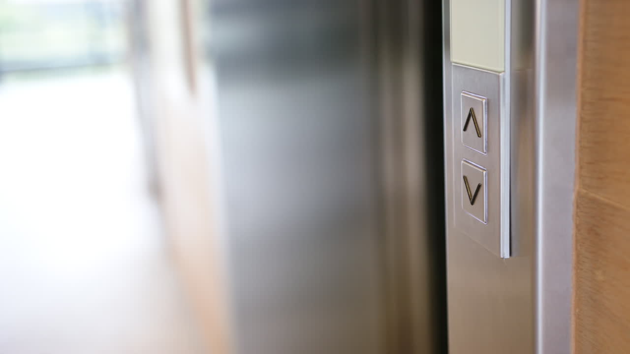 Pressing elevator button, person holding documents, waiting for elevator to arrive