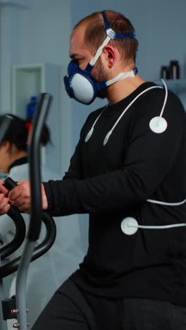 man undergoing physiological fitness test on elliptical trainer in lab