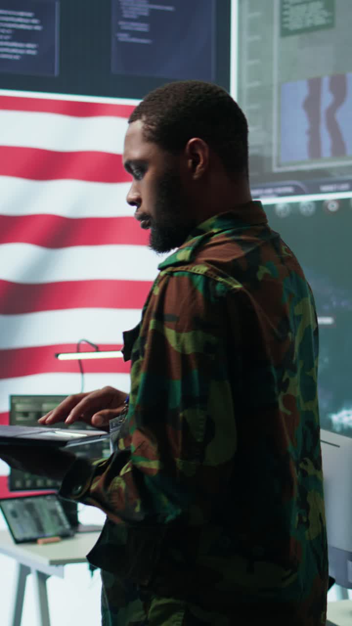 Vertical Video Professionals in US military uniforms operate computers and big screen