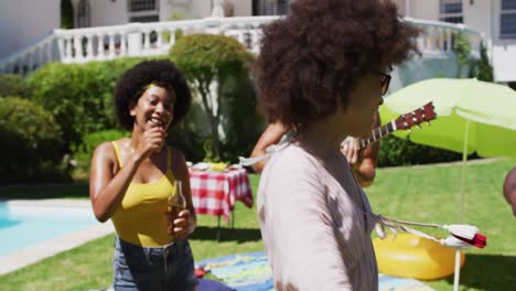 Diverse-group-of-friends-having-fun-and-dancing-at-a-pool-party