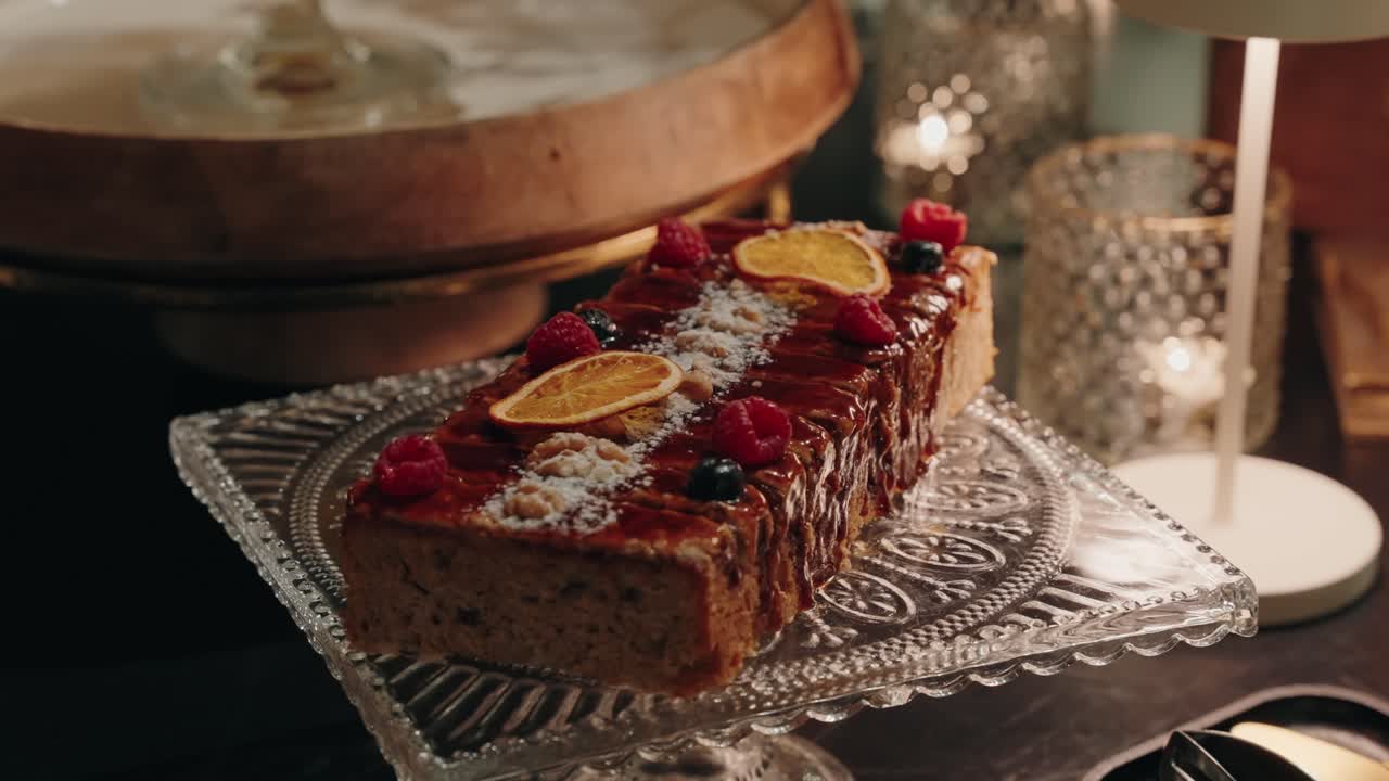 loaf cake with fruit and sugar topping displayed on crystal dessert stand
