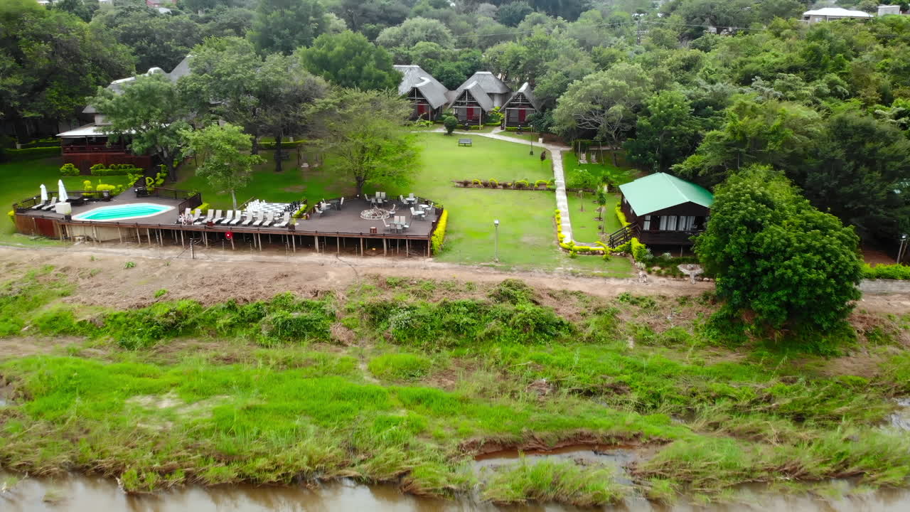 Aerial view of a resort with trees, buildings, and a pool