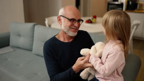 Little-granddaughter-give-a-little-kiss-to-elder-grandfather-at-home