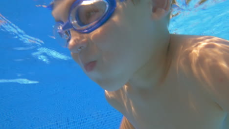 Little-Boy-Swimming-in-the-Pool-between-Relatives