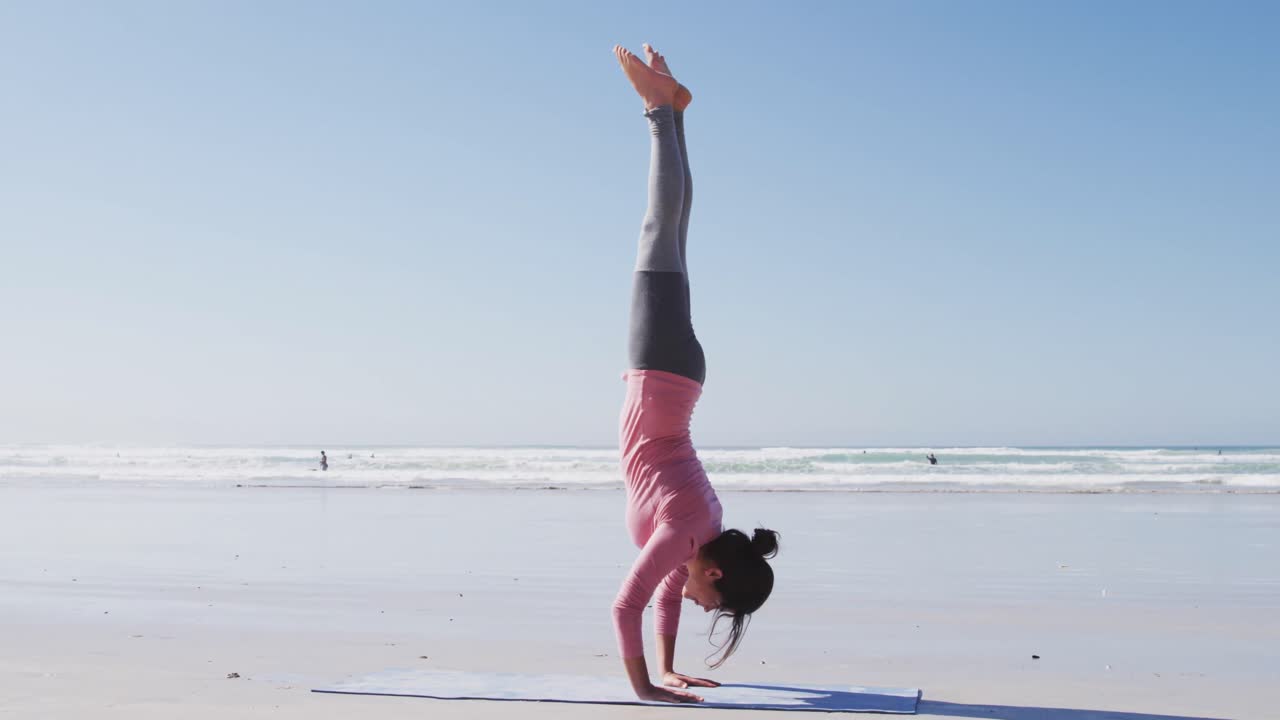 Caucasian woman doing yoga position on the beach and blue sky background
