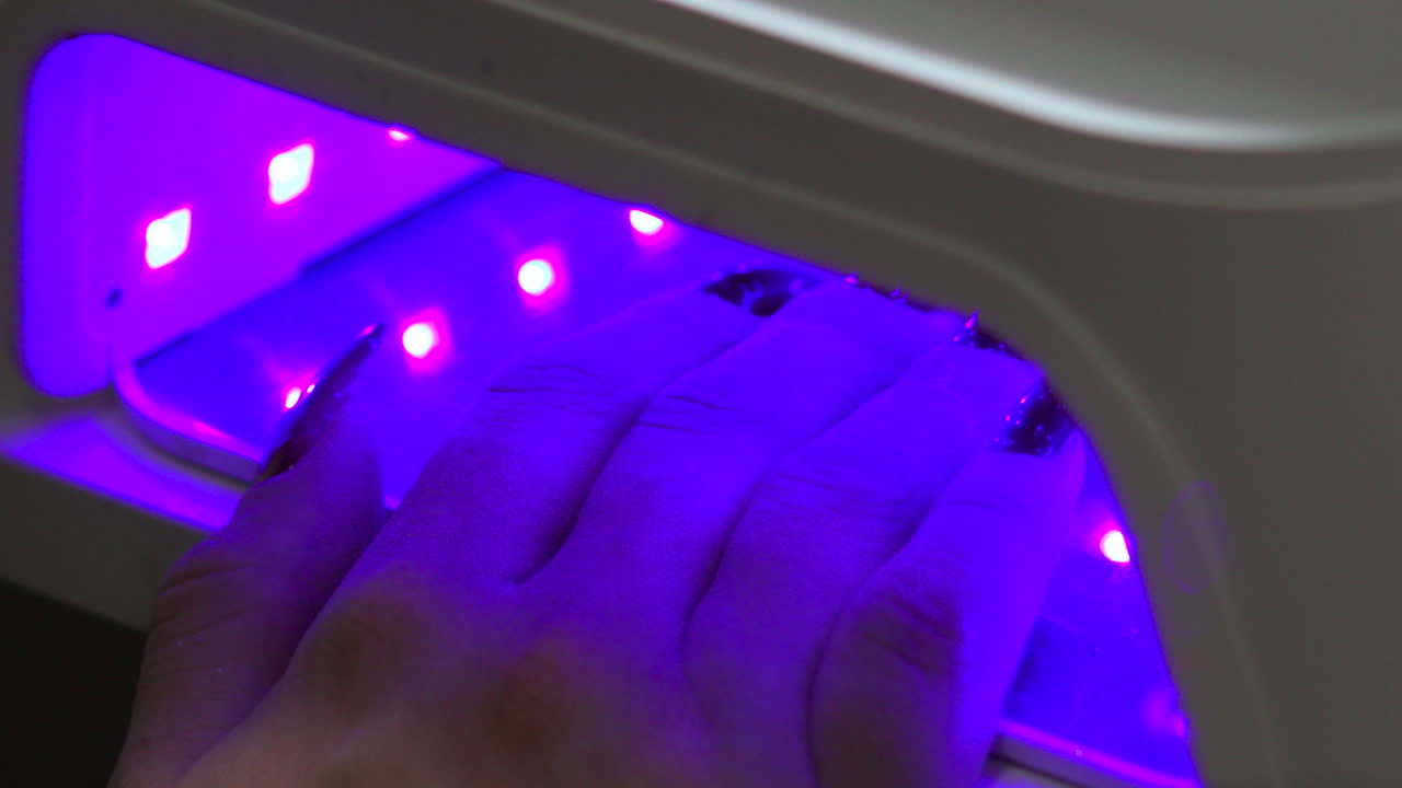 Curing nails with UV nail lamp