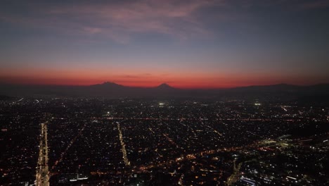 calm, serene sunset and nightfall over mexico city lights, aerial drone
