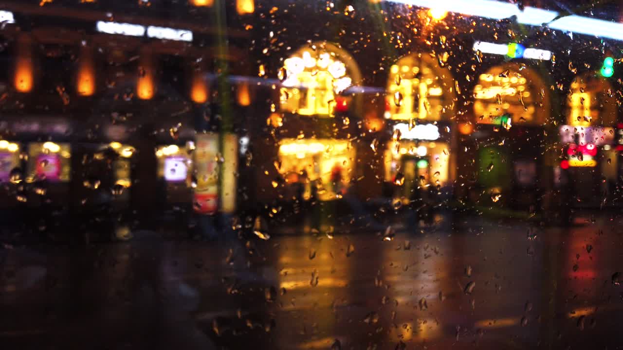비가 내리는 동안 밤의 도시 거리에서 초점을 맞추지 않은 불빛