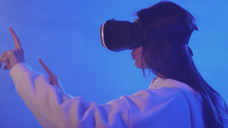 portrait of young woman using a vr headset on a colorful neon light background 1