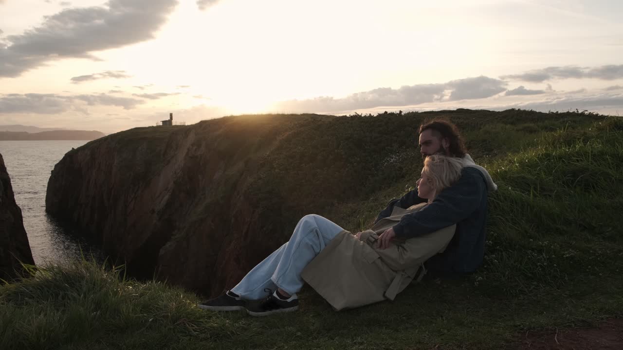Couple admiring sea and sunset sky