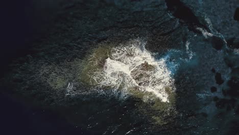 strong sea waves crashing against rock in middle of ocean