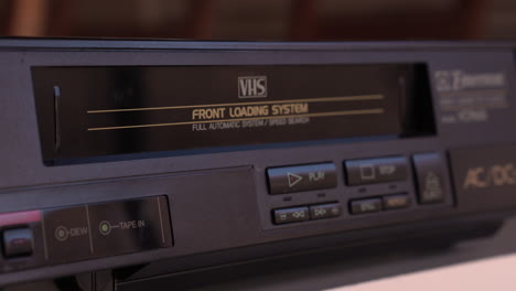 inserting vhs video tape in vcr player, close up