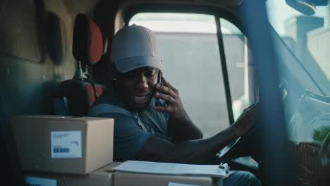 a delivery driver on a phone call in his truck