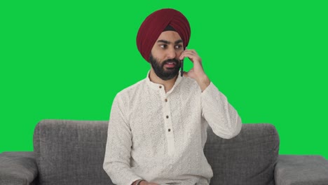 Sikh-Indianer,-Der-Auf-Dem-Grünen-Bildschirm-Des-Telefons-Spricht