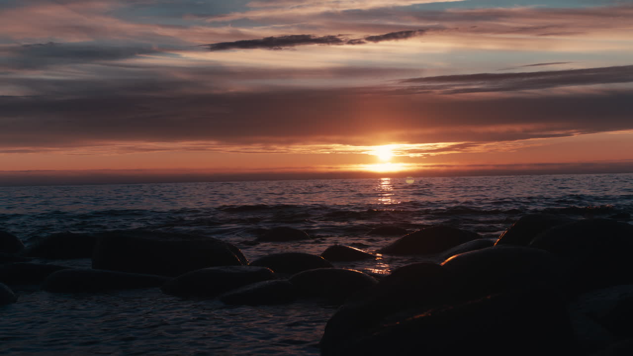 Naturskøn udsigt over en strand med en solnedgang i horisonten på Lofoten i Norge. Solnedgangen giver himlen nogle meget smukke farver.