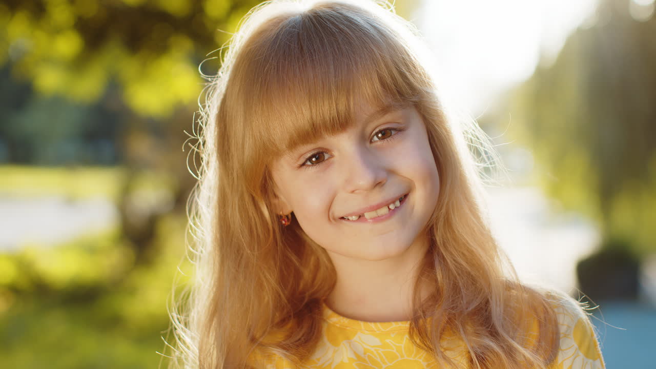 retrato de una niña preadolescente feliz cara sonriente mirando a la cámara buen estado de ánimo satisfecho en el parque