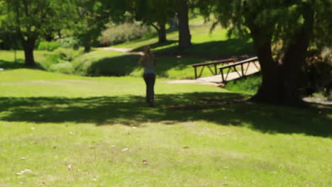 a woman jogs in the park away from the camera