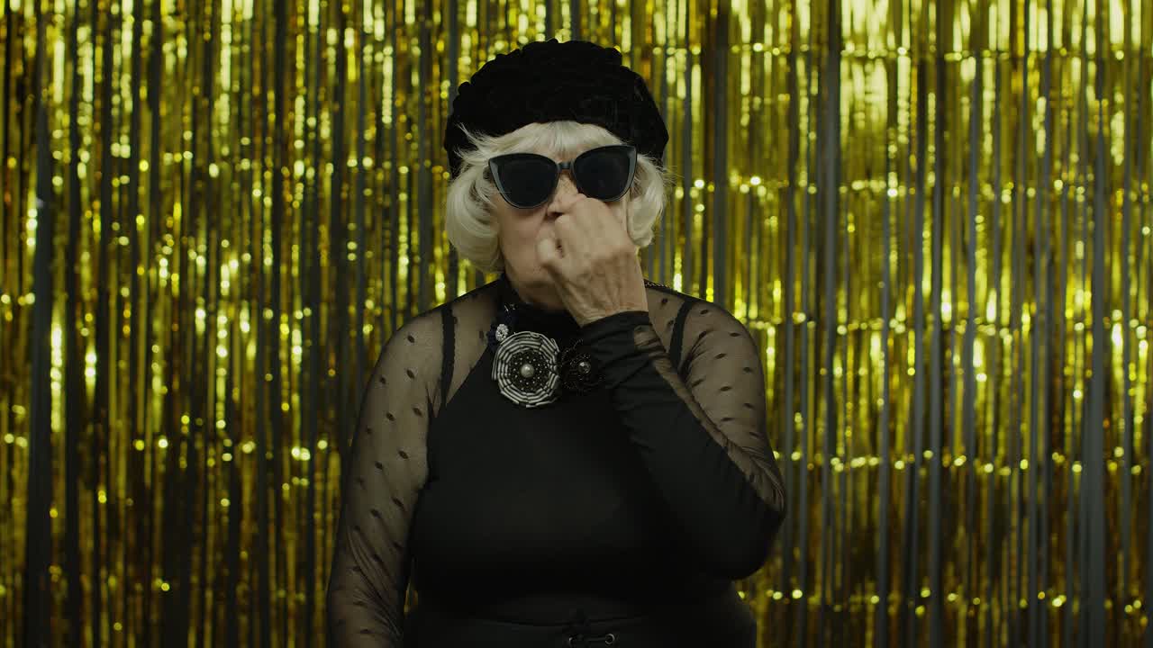Funny stupid senior old woman picking nose with silly expression, removing boogers, bad manners