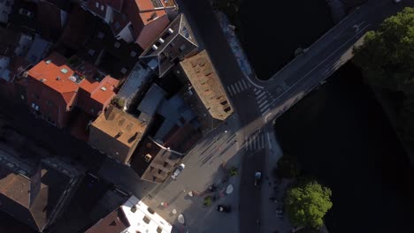 An-aerial-shot-looking-down-onto-a-road-where-people,-cars-and-bikes-are-seen