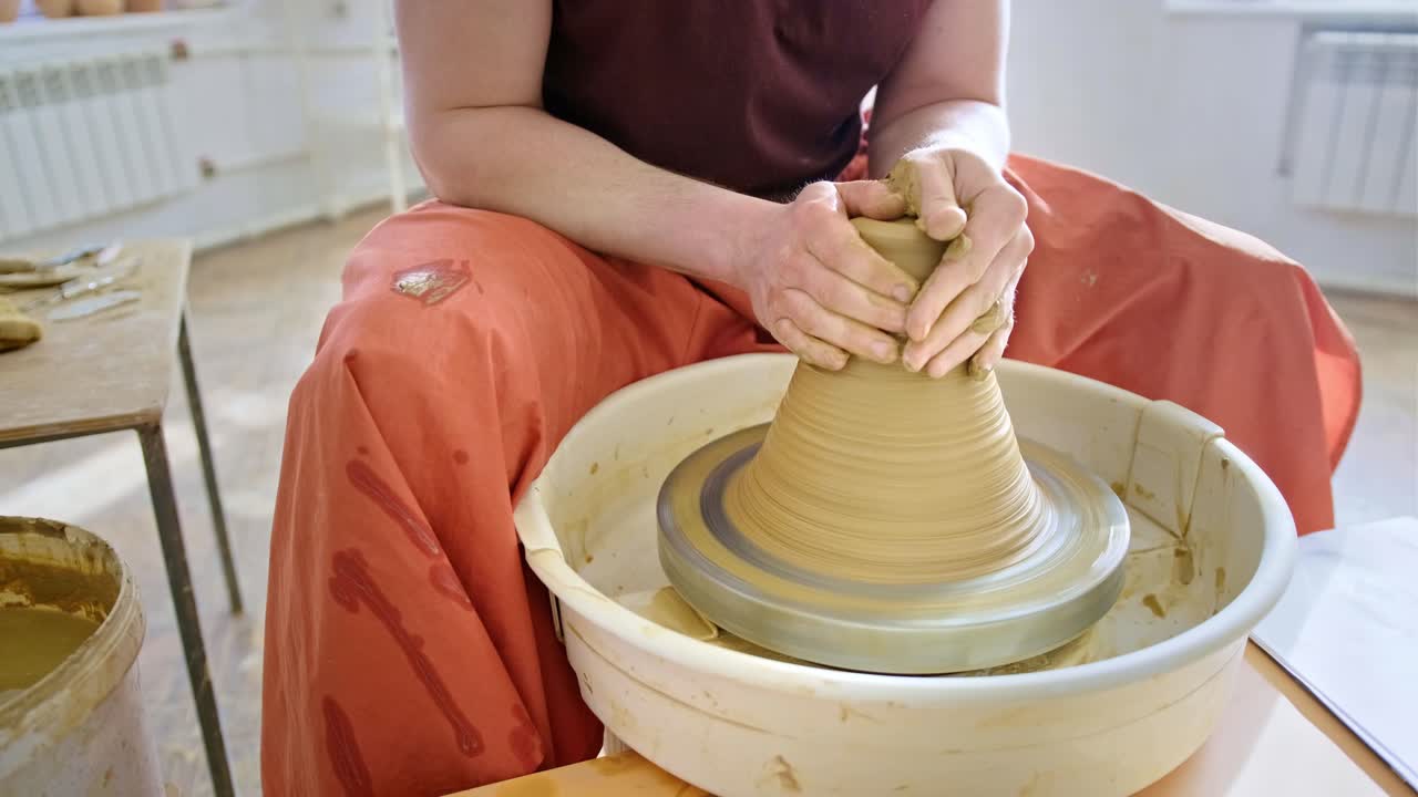persona que da forma a la arcilla en una rueda de cerámica